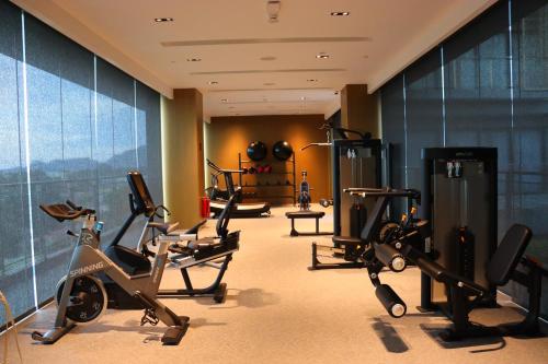 a gym with cardio equipment in a hotel room at Palm Springs Hotel Dili in Dili