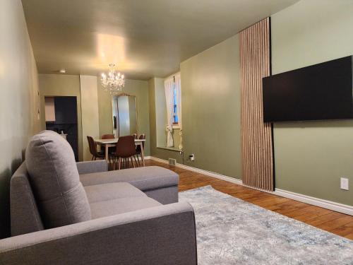 a living room with a couch and a flat screen tv at 2-bed house for downtown, stampede & mountains in Calgary