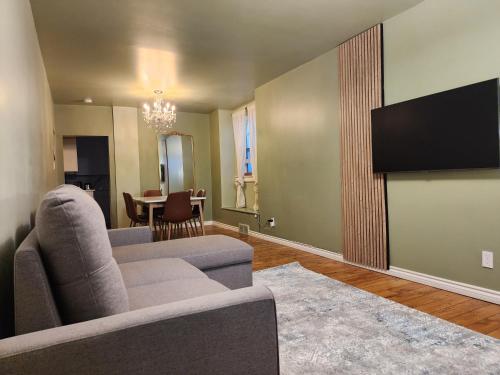 a living room with a couch and a flat screen tv at 2-bed house for downtown, stampede & mountains in Calgary