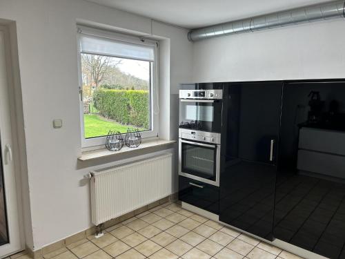 a kitchen with a black stove and a window at Grutsk in Altenstädt