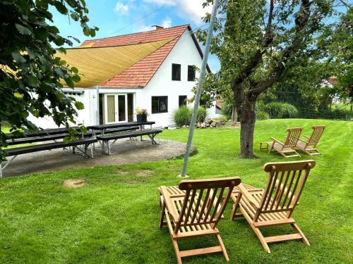 a group of chairs sitting in the grass in front of a house at Grutsk in Altenstädt