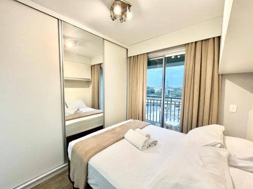a hotel room with a bed and a large window at Flat WiseSP - Expo Anhembi in Sao Paulo