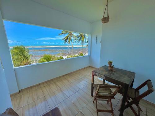 a dining room with a table and a view of the ocean at Casa Praia Beira Mar "PISO SUPERIOR" Guriú,Ce in Camocim