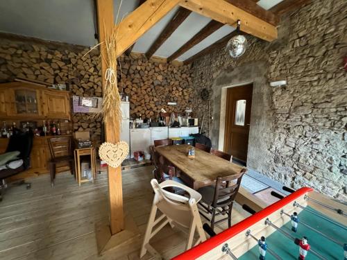 Cette chambre est dotée d'une table, de chaises et d'un mur en pierre. dans l'établissement Escapade campagnarde dans ancien corps de ferme, à Avolsheim