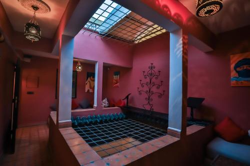 a room with a pink wall with a window at Riad Skilfo in Fès