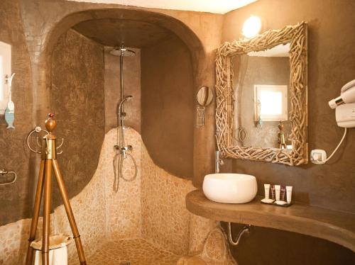 a bathroom with a sink and a mirror at Hôtel Ambassador Palombaggia in Porto-Vecchio