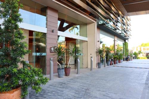 a building with potted plants on the side of it at Palm Springs Hotel Dili in Dili
