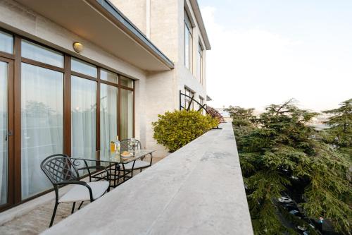 a table and chairs on the balcony of a building at Citrus Hotel in Tbilisi City