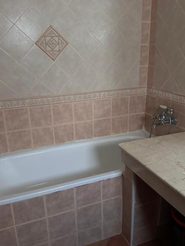 a bathroom with a bath tub and a counter at Marinasmir Jawhara in Fnidek