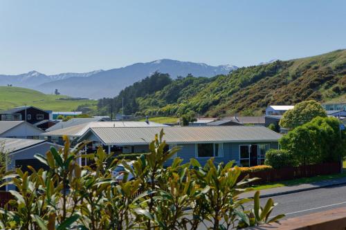 a view of a town with mountains in the background at A Classic Kiwi Bach in South Bay in Kaikoura