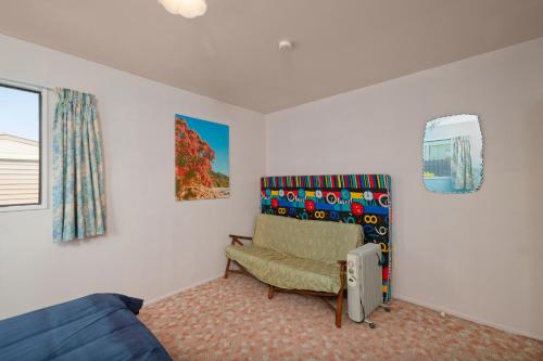 a living room with a blue couch and a chair at A Classic Kiwi Bach in South Bay in Kaikoura