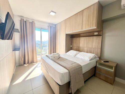 a bedroom with a bed and a large window at Flat WiseSP - Expo Anhembi in Sao Paulo