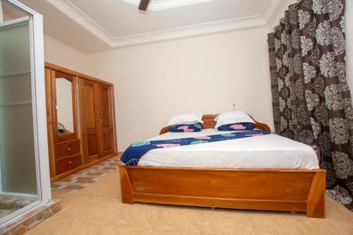 a bedroom with a bed and a mirror in it at Yaa Asantewaa Inn in Ejisu