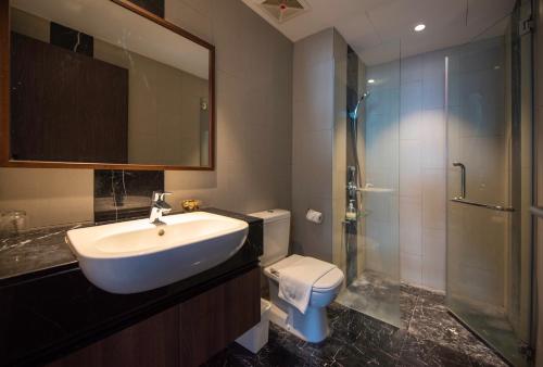 a bathroom with a sink and a shower and a toilet at The Landmark Seaview Suite in Tanjong Tokong