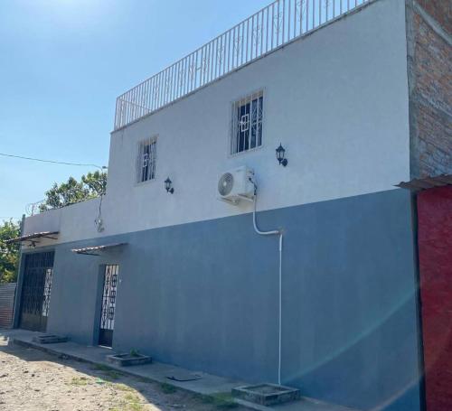 un edificio blanco con dos ventanas laterales en Habitación cerca del aeropuerto #3, en La Paz