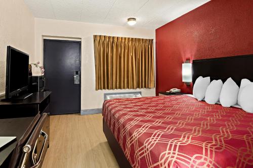 a hotel room with a bed and a television at Bellmawr Economy Inn Bellmawr-Philadelphia Area in Bellmawr