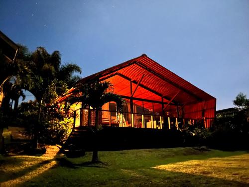 a building with a red roof in a field at Chalet Zen Bella Vista in San Juan