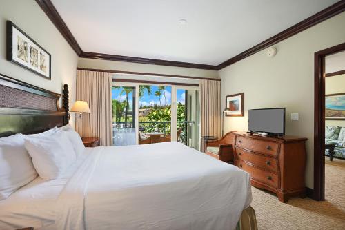 a bedroom with a white bed and a television at Waipouli Beach Resort and Spa Kauai by OUTRIGGER in Kapaa