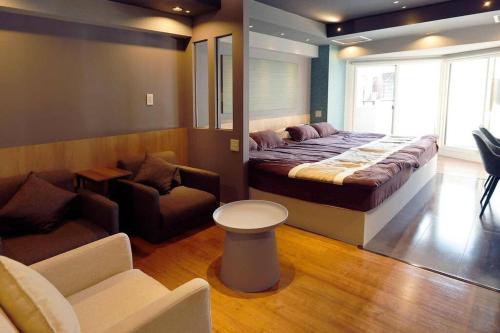 a bedroom with a bed and a couch and a chair at MolinHotels102-アクティビティを満喫できる札幌定山渓 天然温泉付 - W-beds2&S-beds3 in Jozankei