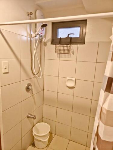 a bathroom with a shower with a toilet and a window at 1BR T2 with Balcony Panoramic View at Horizons 101 in Cebu City