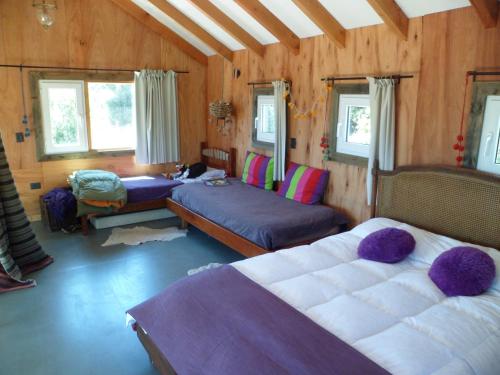 1 dormitorio con 2 camas en una habitación con paredes de madera en Un Viston Modern Mountain Home en San Martín de los Andes