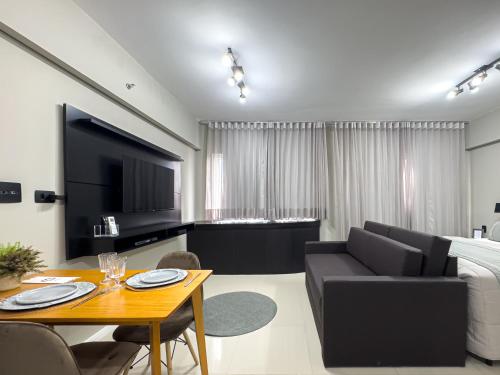 a living room with a couch and a dining room at Suíte Pátio Paulista 1404 in Sao Paulo