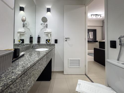 a bathroom with two sinks and a shower at Suíte Pátio Paulista 1404 in Sao Paulo