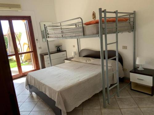 Un dormitorio con dos literas y una ventana. en Casa vacanza Monica, en Villasimius