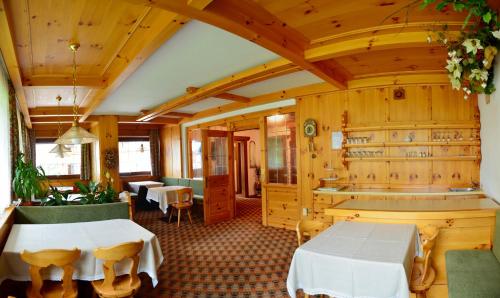 a restaurant with wooden walls and tables and chairs at Garni Sayonara in San Vigilio Di Marebbe