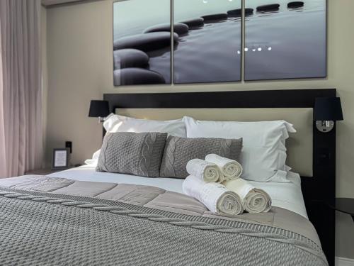 a bedroom with a bed with rolled towels on it at Suíte Pátio Paulista 1404 in Sao Paulo