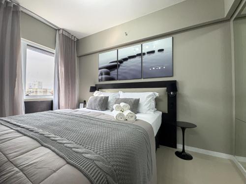 a bedroom with a large bed with towels on it at Suíte Pátio Paulista 1404 in Sao Paulo