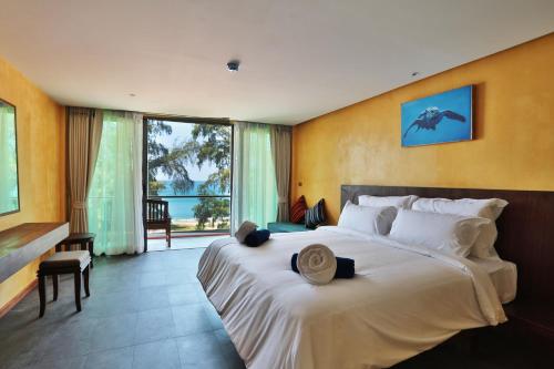 - une chambre dotée d'un grand lit avec un chapeau dans l'établissement Coriacea Beachfront Boutique Phuket Resort, à Mai Khao Beach