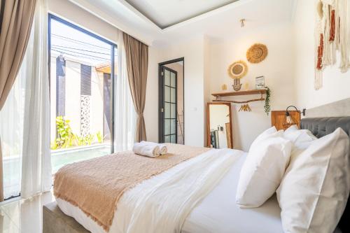 a bedroom with a bed and a large window at Kamaratih Villas by Maheswara in Legian