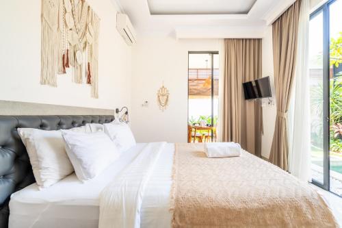 a bedroom with a large bed with white pillows at Kamaratih Villas by Maheswara in Legian