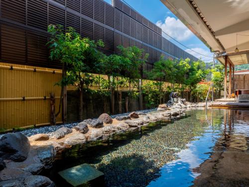 a large building with a pond in front of it at Hotel Sunvalley Fujimi in Izunokuni