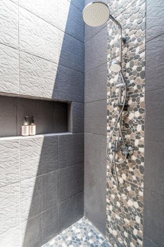 a bathroom with a shower with a glass door at Kamaratih Villas by Maheswara in Legian