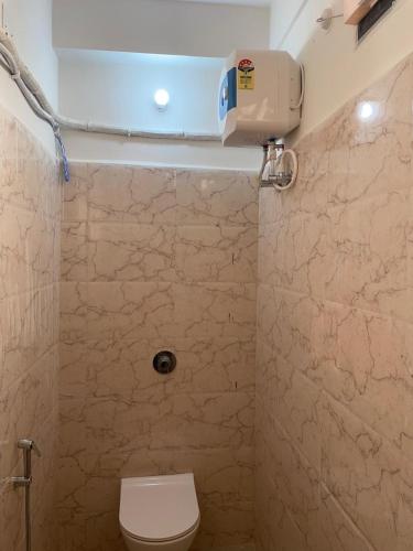 a bathroom with a toilet and a air conditioner at Shrinath Palace in Deoghar