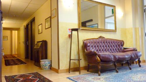 a leather chair in a room with a mirror at Hotel della Vittoria in Ancona