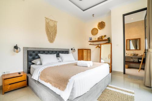 a bedroom with a large bed and a bathroom at Kamaratih Villas by Maheswara in Legian