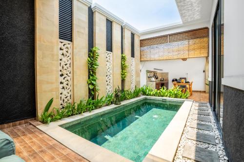an indoor swimming pool in the middle of a house at Kamaratih Villas by Maheswara in Legian