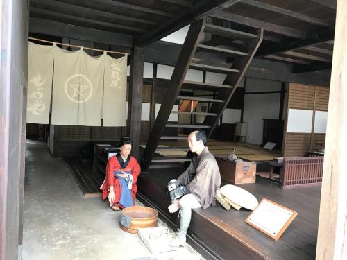 two people sitting on a bench in a room at Hotel Arc Riche Toyohashi in Toyohashi