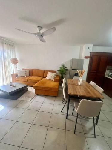 a living room with a couch and a table at Beau T2 en Rez de jardin in Saint-Denis