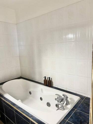 a white bath tub with a faucet in a bathroom at Beau T2 en Rez de jardin in Saint-Denis