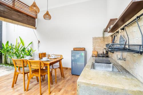 a kitchen with a table and chairs and a sink at Kamaratih Villas by Maheswara in Legian