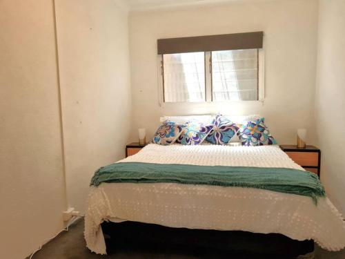 une chambre avec un grand lit avec une fenêtre dans l'établissement Crab Claw Cottage, à Port Broughton