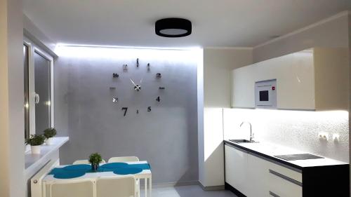kuchnia z zegarem na ścianie w obiekcie Apartamenty Krawiecka w Zielonej Górze
