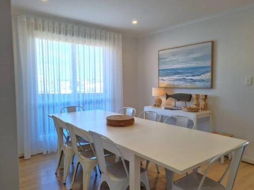 a dining room with a white table and chairs at Hamilton House in Port Hughes