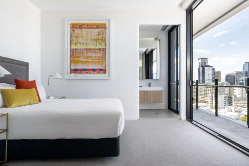 a bedroom with a white bed and a large window at The Johnson Brisbane - Art Series in Brisbane