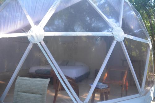 a view of a tent with a bed and chairs at Glamping Mayan Glam in Tulum