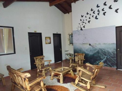 サン・ヒルにあるCasa HOTEL EL MARQUEZの椅子と壁に鳥が飾られた部屋